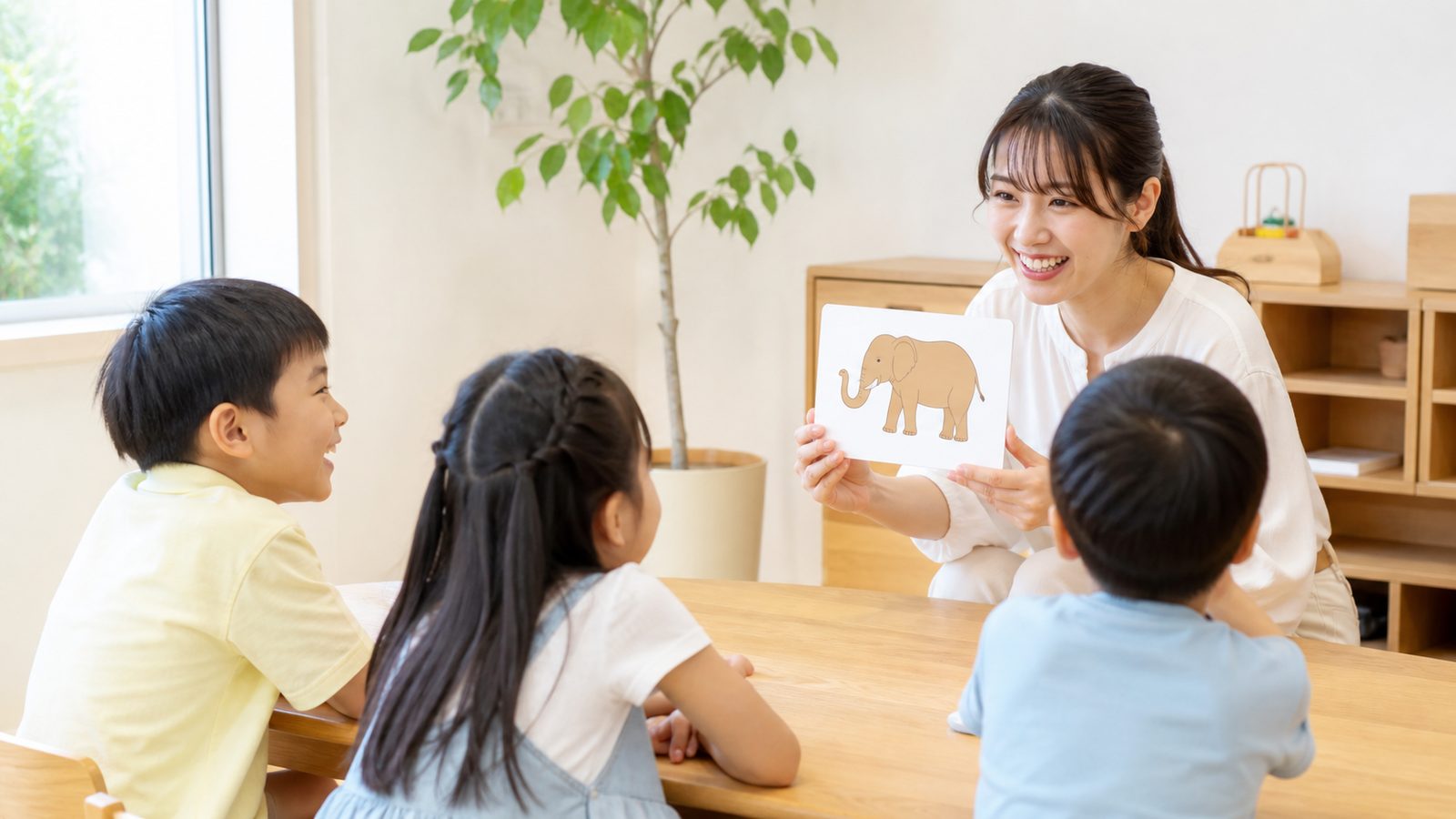 絵カードを使ったレッスンのようす。先生と子どもたちが机を囲んでいる